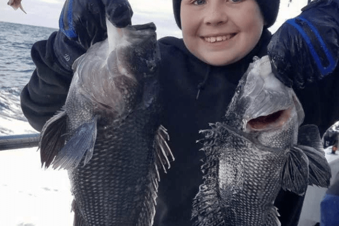 a little boy holding a fish