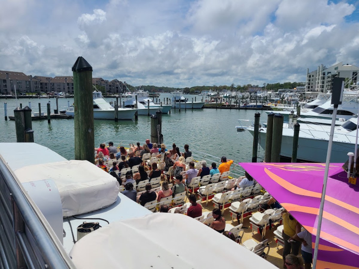 a group of people on a dock next to a body of water