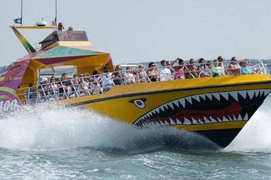 a man riding on the back of a boat in the water
