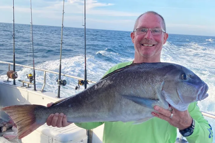 a man holding a fish in the water