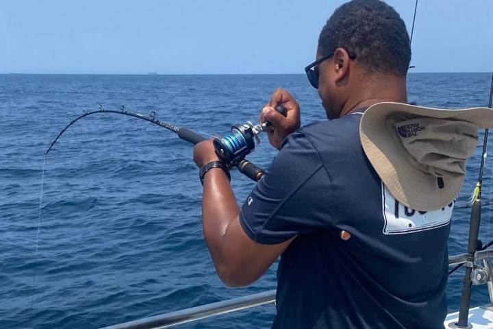 a man standing next to a body of water