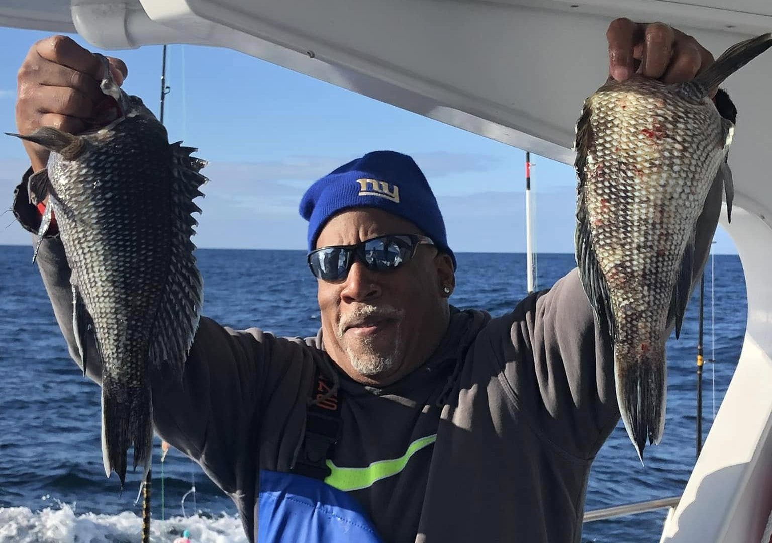 a man holding a fish on a boat